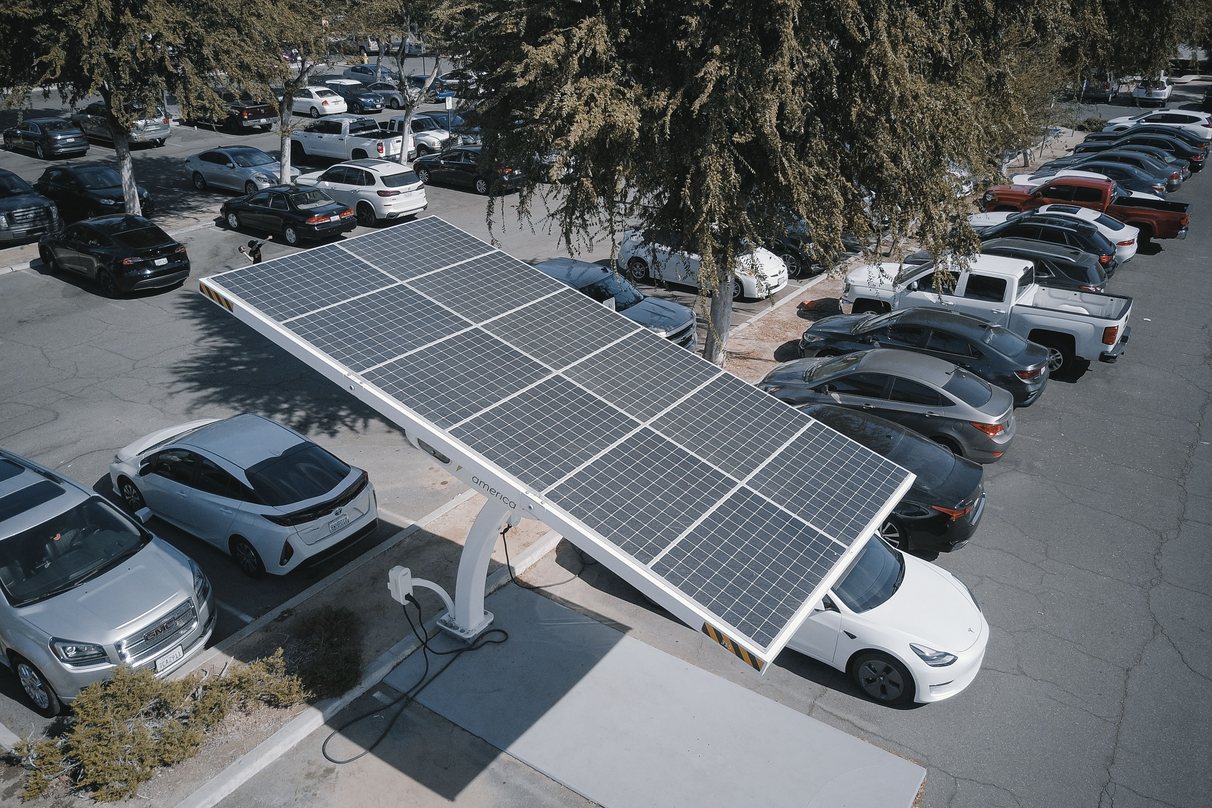 Electric vehicles parked around a solar-powered charging canopy